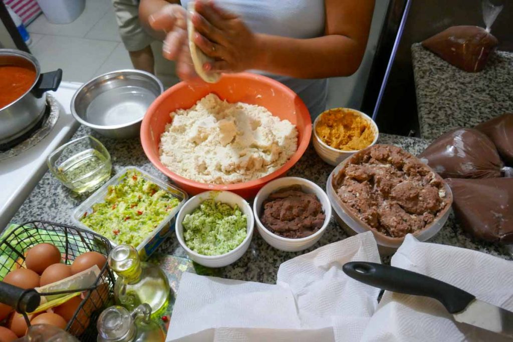How to make pupusas step 3. Turn and pat the filled pupusa dough ball to flatten it.
