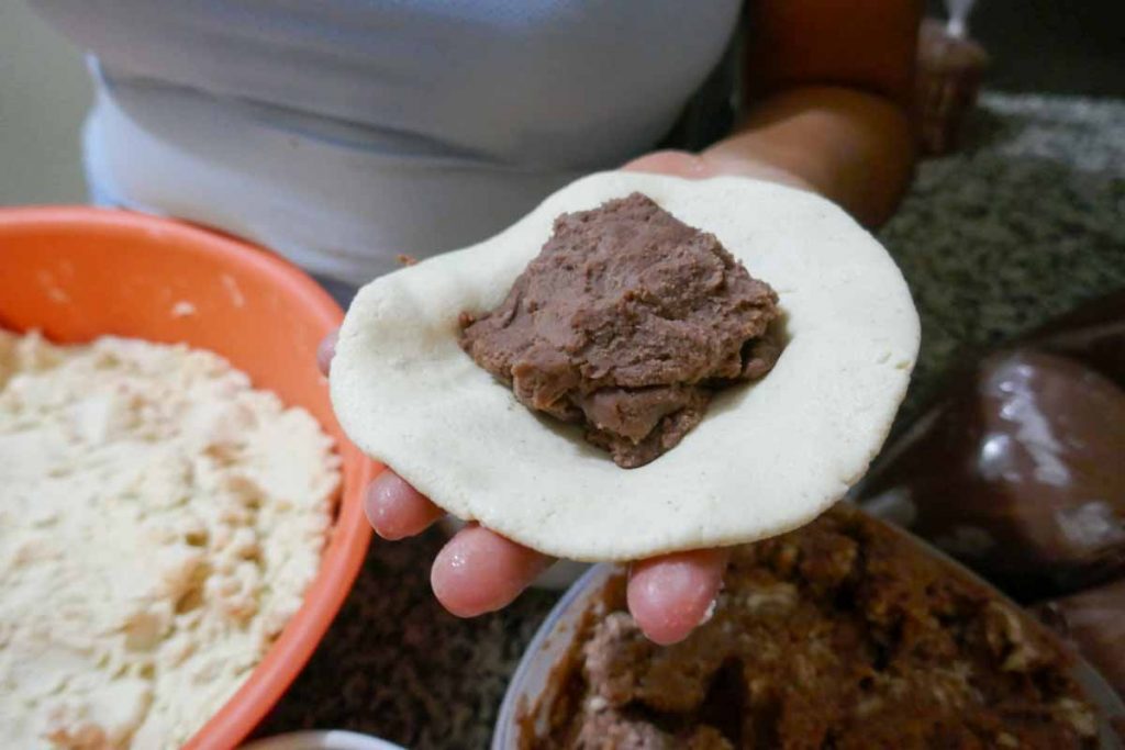 How to make pupusas step one. Put the pupusa filing in the middle of a flat circle of pupusa dough.