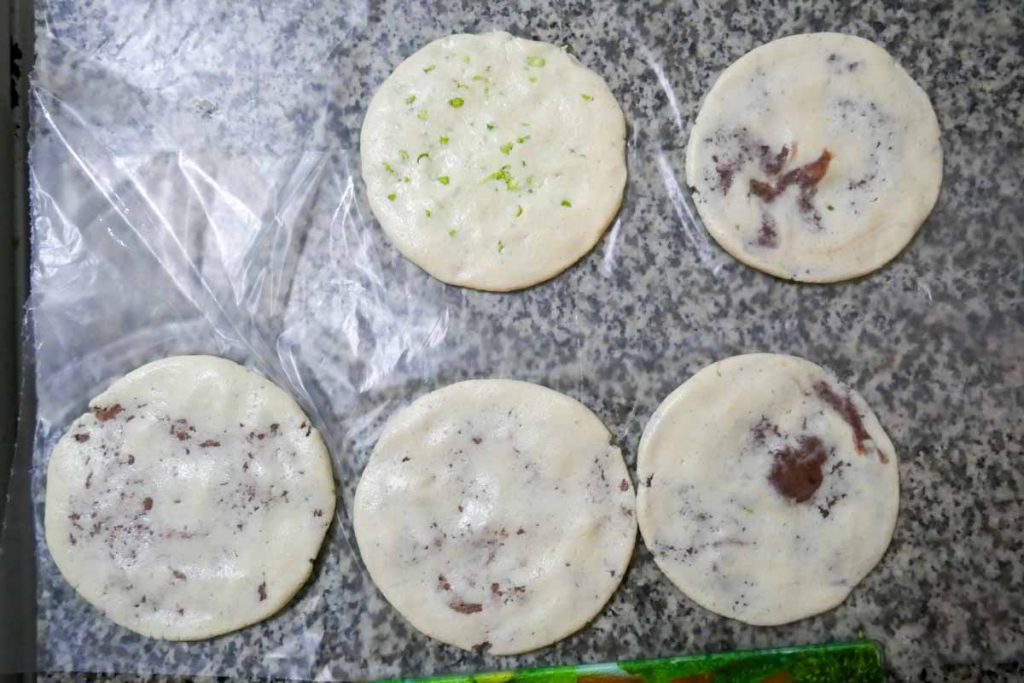 How to make pupusas step four. Lay out pupusas on film to keep them separate before cooking.